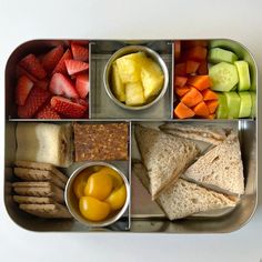 a bento box filled with fruit, crackers, and other foodstuffs