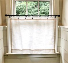 a bathroom with a white toilet sitting next to a window