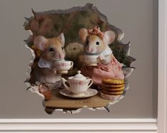 two mouses sitting at a table with tea cups and cookies