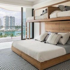 a bedroom with two bunk beds and a balcony overlooking the water in front of it