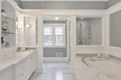 a large bathroom with two sinks, tub and walk - in shower next to each other