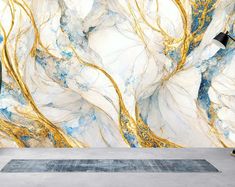 an artistic marble wallpaper with gold and blue swirls in the center, along with a rug on the floor