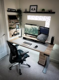 a computer desk with two monitors and a laptop on it in front of a doorway