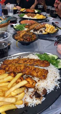 a table filled with lots of different types of food on top of plates and serving utensils