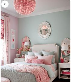 a bedroom decorated in pink and blue with a chandelier hanging from the ceiling