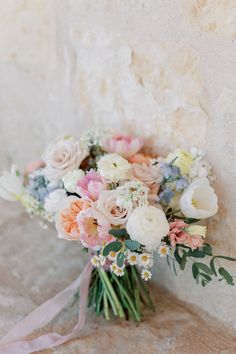 a bouquet of flowers sitting on top of a stone wall