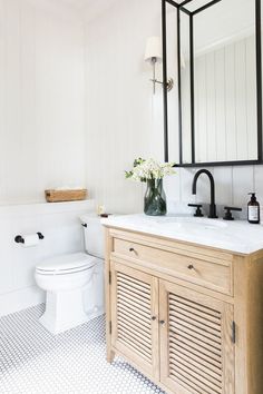 a bathroom with a sink, toilet and mirror in it's centerpieces