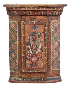 an ornate wooden cabinet with painted designs on the front and sides, isolated against a white background