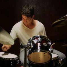 a man playing drums in front of a microphone