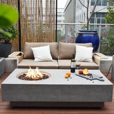 a fire pit sitting on top of a wooden floor next to chairs and couches