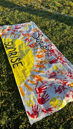 a yellow and red sign laying in the grass