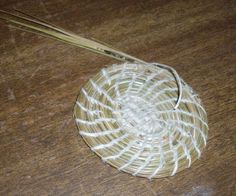 a piece of white yarn sitting on top of a wooden table next to a pair of scissors