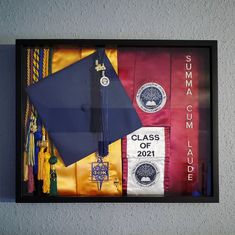 a graduation cap, tassel and other items are on display in a shadow box