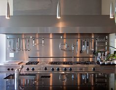 a large stainless steel stove top oven sitting inside of a kitchen next to a counter