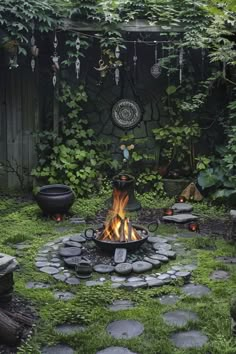 an outdoor fire pit surrounded by stones and greenery