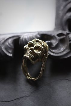 Skull with thorn ring by Defy. - The Skull dimensions are approx. 2x2.8 cm. - The Ring size is adjustable between 7-10 US. - Material : Brass / Silver **Free Shipping to World Wide** - Please allow us to prepare the item and parcel between 3-5 working days. For Brass / Silver plated / Gold plated (Between 5-7 working days For Sterling Silver 925) (Between 7-10 working days For Special items Sterling Silver925 with Hand painted) - All items will be sent by Thai Registered Airmail. The delivery us Adjustable Skull Rings With Symbolic Style, Unique Metal Rings For Halloween, Adjustable Unique Metal Skull Ring, Unique Hand Cast Rings For Halloween, Adjustable Metal Skull Ring, Unique Skull Rings For Gifts, Unique Adjustable Hand Cast Skull Ring, Gothic Gold Rings For Halloween, Handmade Gothic Gold Ring