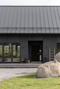 a large rock sitting in front of a black building