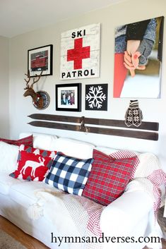 a living room with white couches and pictures on the wall above them, along with christmas decorations