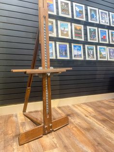 a wooden easel sitting on top of a hard wood floor next to a wall