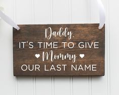 a wooden sign that says daddy it's time to give mommy our last name