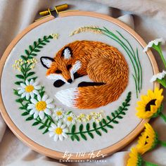 an embroidered fox with flowers and leaves on it