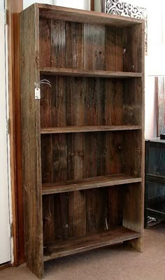 a wooden bookcase sitting in the corner of a room