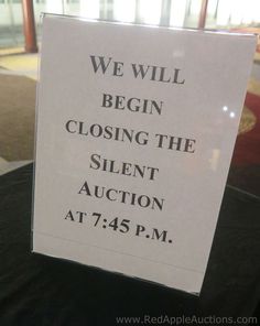 a sign that says we will begin closing the silent auction at 745 pm on display