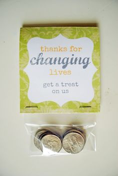 two coins are sitting next to each other in front of a card that says thanks for changing lives get a treat on us