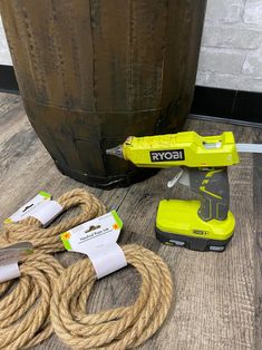 a corded sanding machine sitting on top of a wooden floor next to a barrel