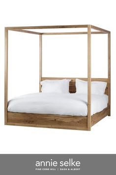 an image of a bed that is made with wood and white linens on it