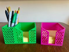 two plastic containers with pens and pencils in them sitting on a wooden table next to each other