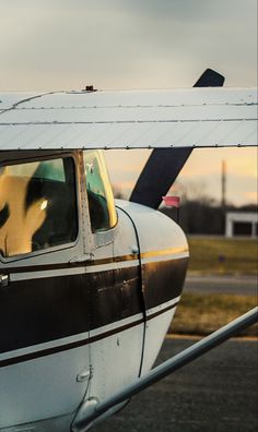 an airplane with its door open sitting on the tarmac next to some grass and trees