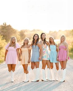 a group of women standing next to each other on a road