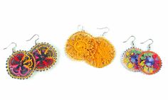 three different types of earrings are shown on a white surface, one is orange and the other is red