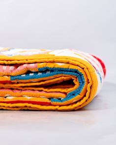 two folded pieces of fabric sitting on top of each other in front of a white background