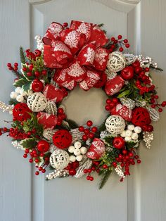 a red and white christmas wreath on a door