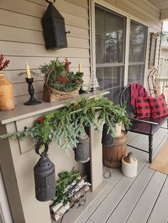 a porch decorated for christmas with potted plants and candles