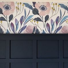 a close up of a wall with flowers and leaves painted on the side of it