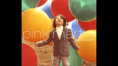 a young boy standing in front of balloons with the words pink martini on it's side