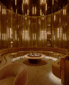 a living room filled with lots of furniture and walls covered in gold glass coverings