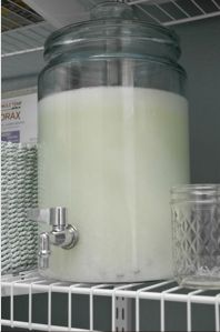 a glass jar filled with white liquid sitting on top of a shelf