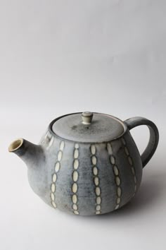 a ceramic teapot with white dots on it