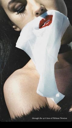 a woman with long black hair and red lipstick holding a piece of tissue over her mouth