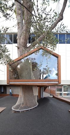 an unusual tree house in the middle of a parking lot with a large mirror on it's side