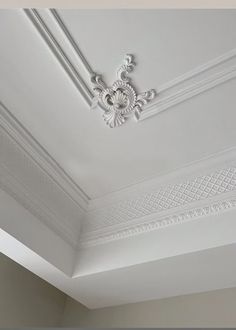 the ceiling in this room is decorated with white paint and decorative moldings on it