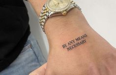 a person with a watch on their wrist that says by any means necessary to tattoo