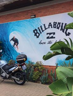 a motorcycle is parked in front of a large advertisement for billabong z2