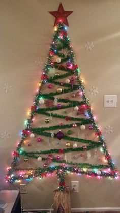 a christmas tree decorated with lights and ornaments in the shape of an xmas tree