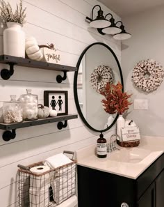 a white bathroom with black and white decor on the wall, shelves above the sink