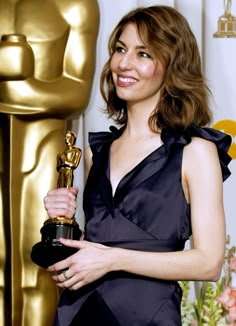 the actress poses with her oscar statue